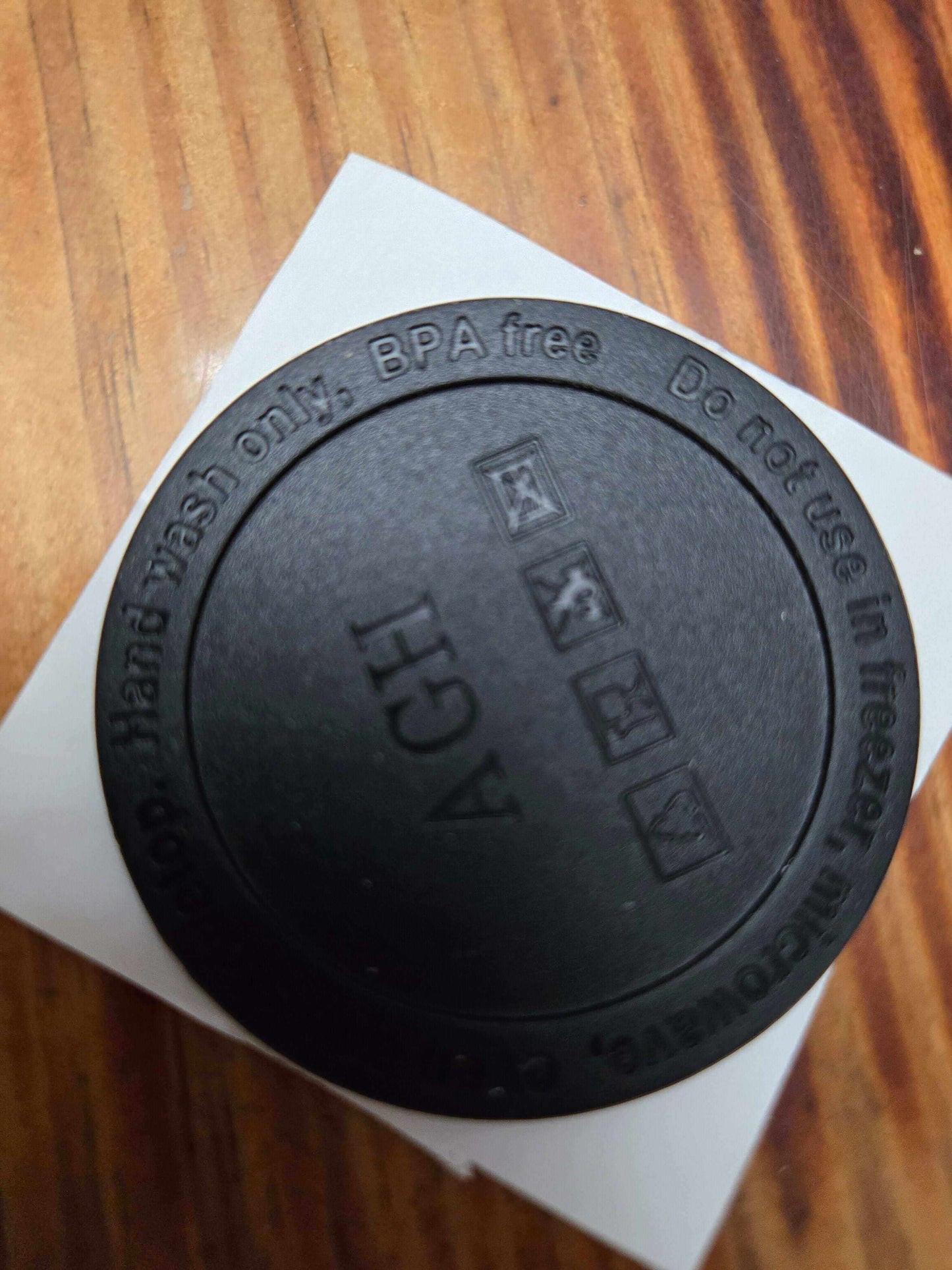 Bottom view of a BPA-free tumbler lid with care instructions and icons for washing and use.