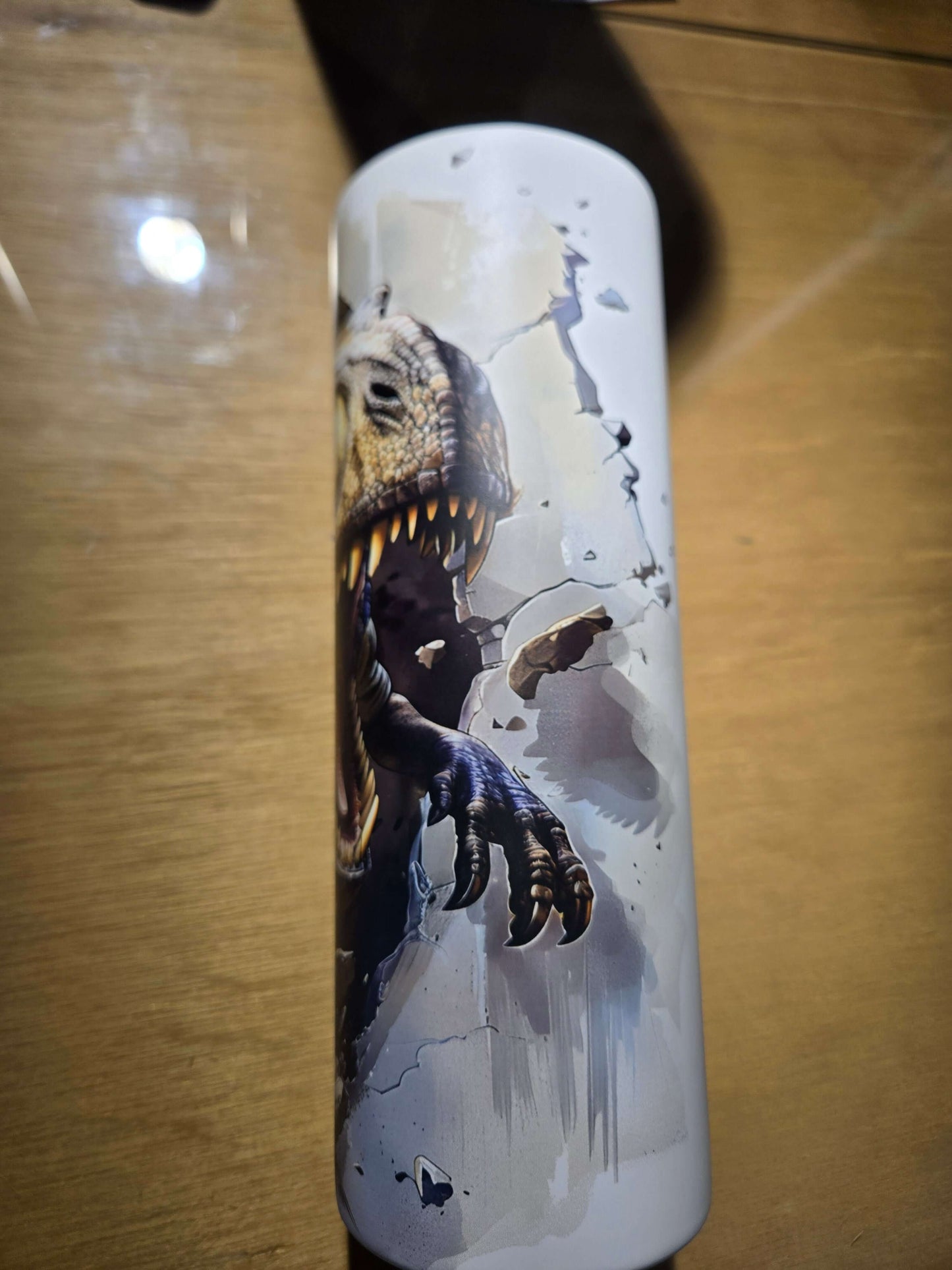 T-Rex glow in the dark tumbler cup featuring a roaring dinosaur design against a cracked wall background.