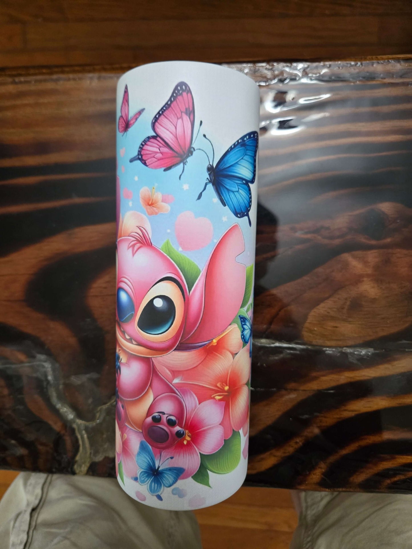 Colorful Stitch illustration surrounded by flowers and butterflies, perfect for a playful tumbler design.