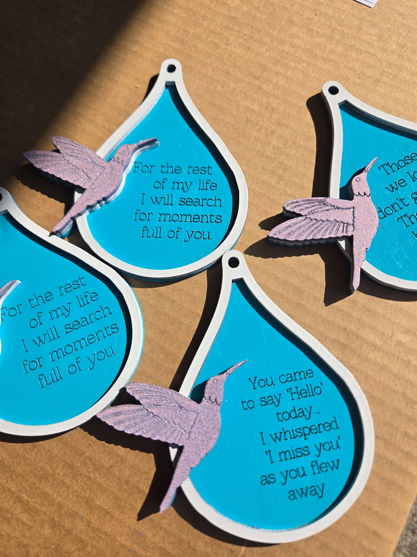 Humming bird xmas ornaments with quotes on vibrant blue teardrop shapes for holiday decor.