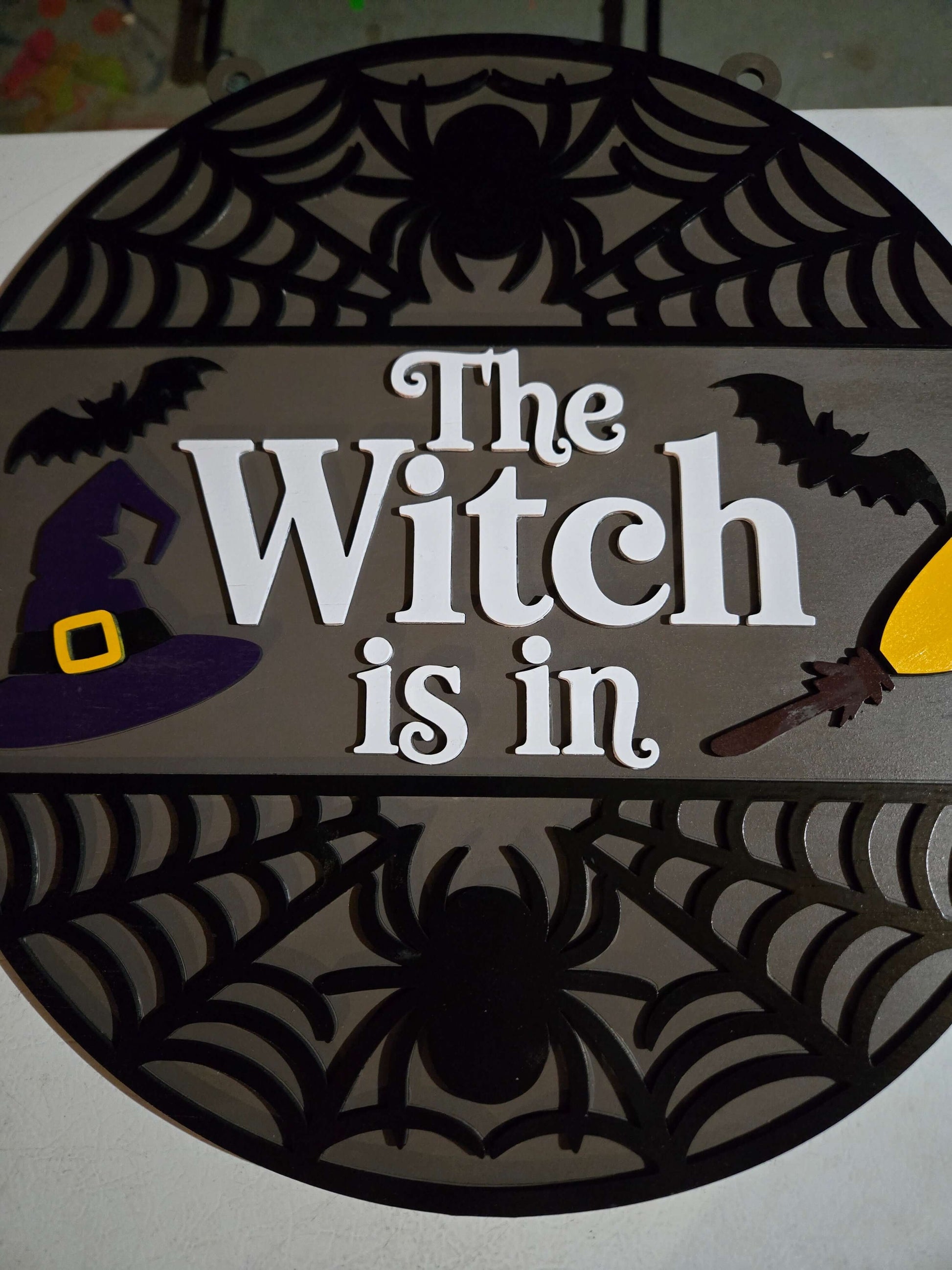 The Witch is in Halloween decor featuring a whimsical design with a witch hat and spooky elements.