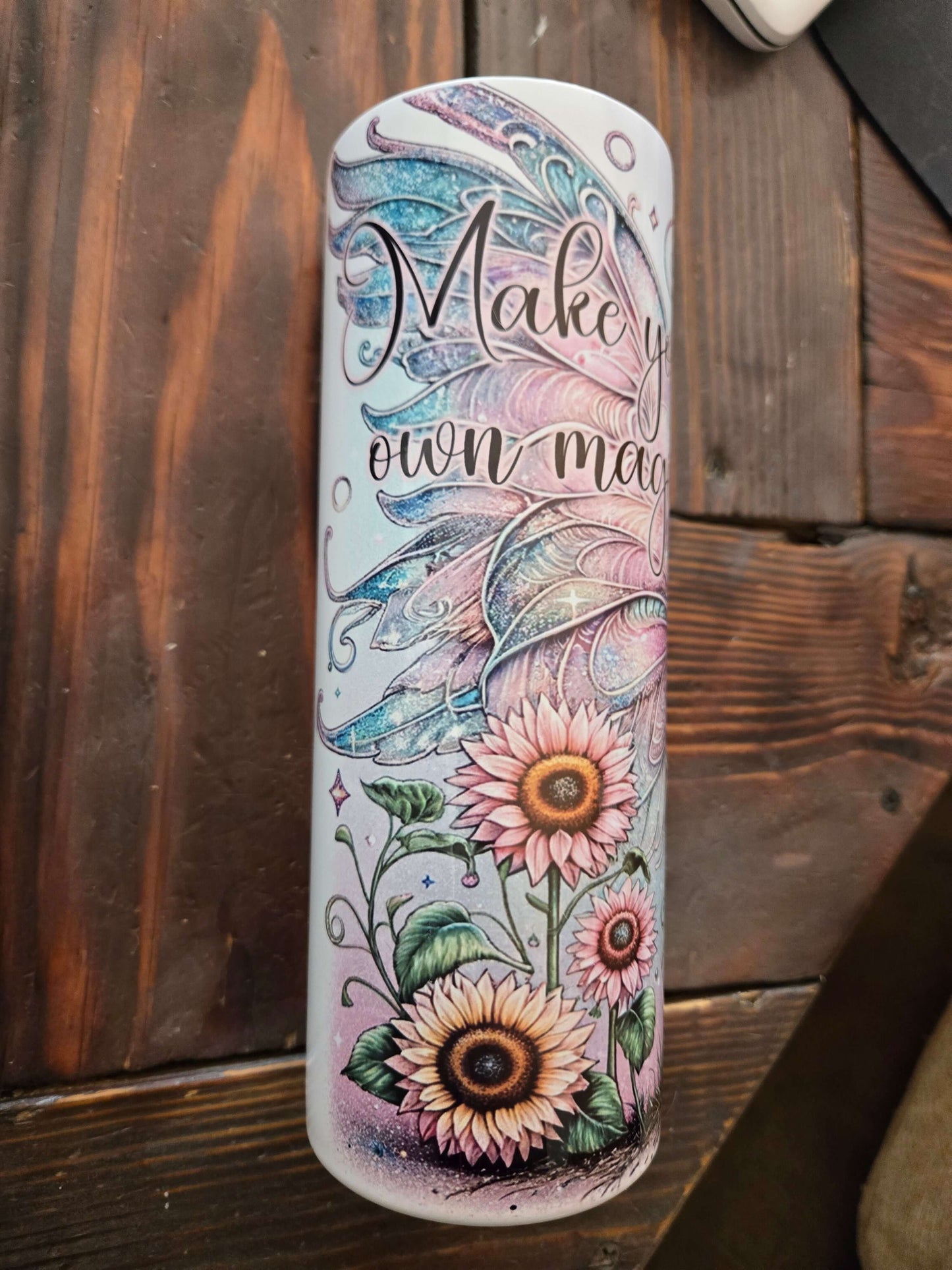 Colorful 20oz tumbler cup with floral design and 'Make Your Own Magic' text, ideal for travel and everyday use.