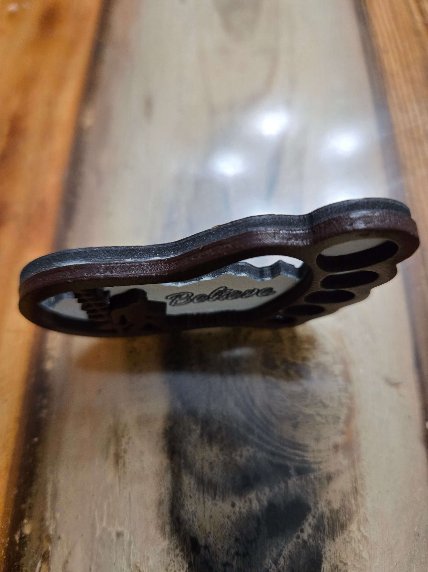 Handmade Bigfoot keychain on a wooden surface, showcasing unique carved design for travel and organization.