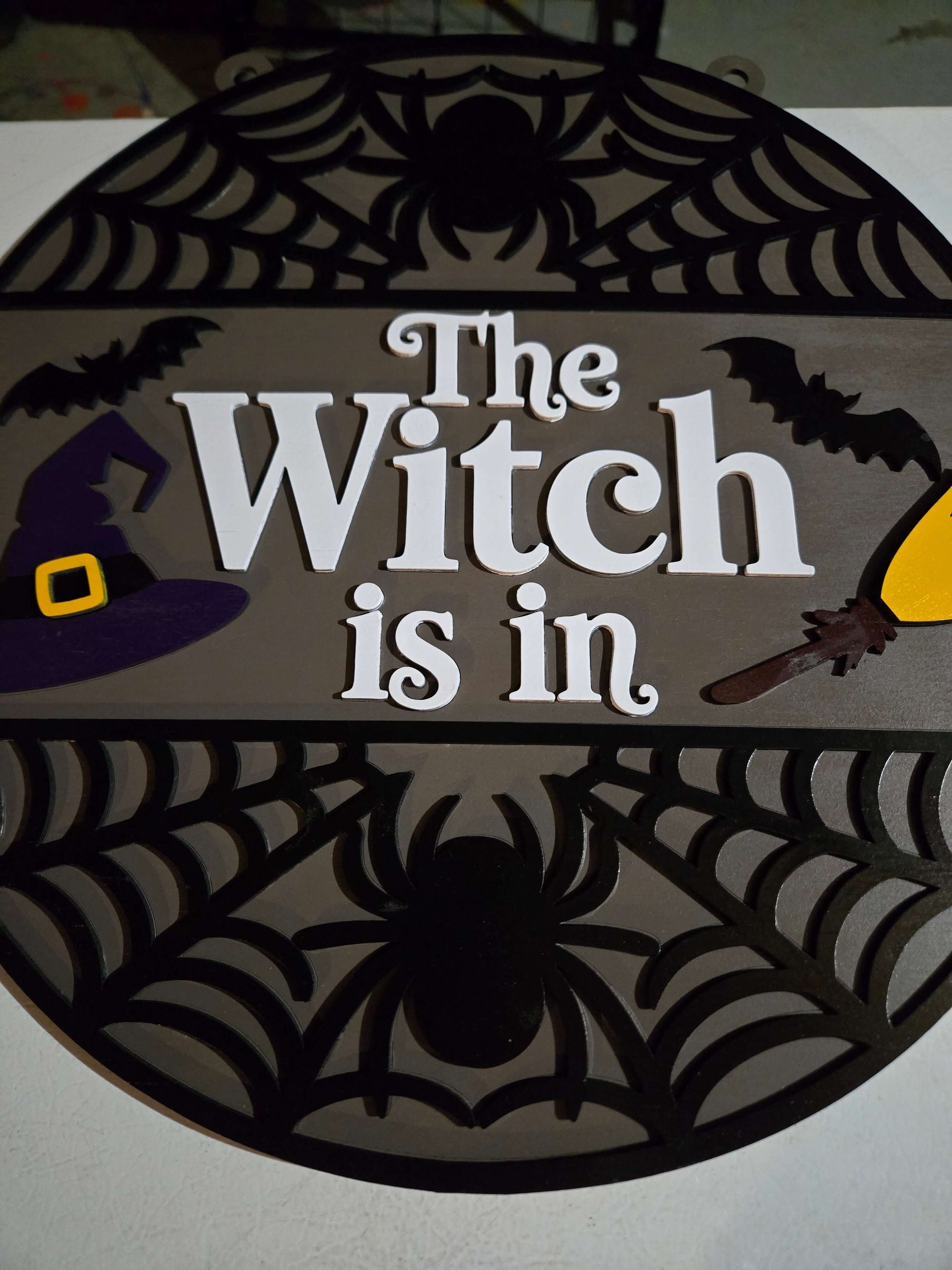 The Witch is in Halloween decor with playful witch design, spiders, and festive elements.