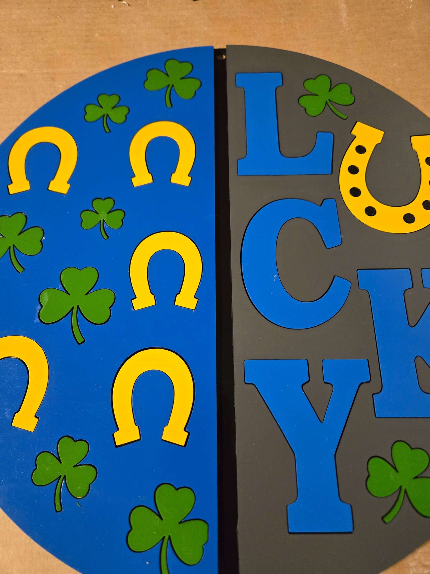 Wooden sign featuring the word 'LUCKY' with shamrocks and horseshoes for St. Patrick's Day decor.