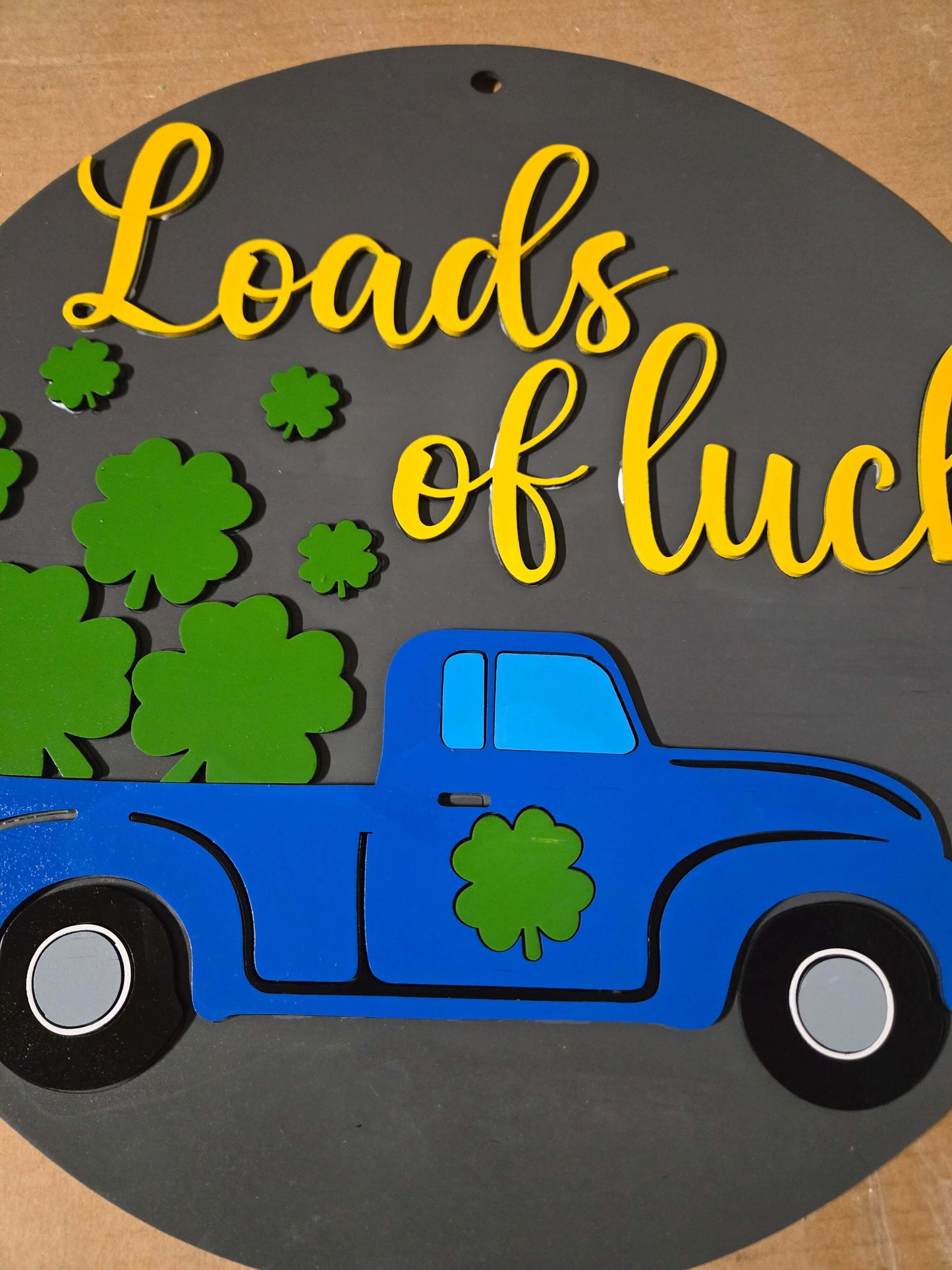 St. Patrick's Day Loads of Luck wooden decor sign featuring a blue truck and shamrocks.