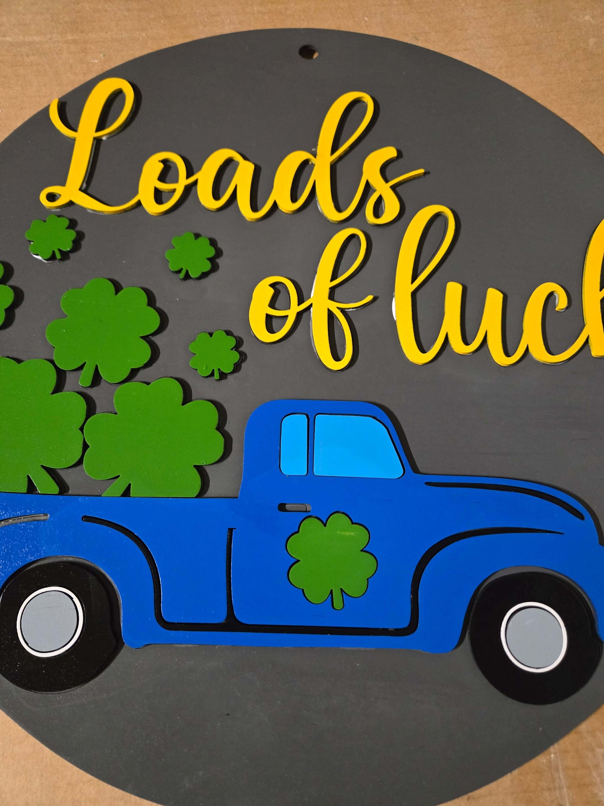 St. Patrick's Day Loads of Luck wooden decor sign featuring a blue truck and shamrocks.
