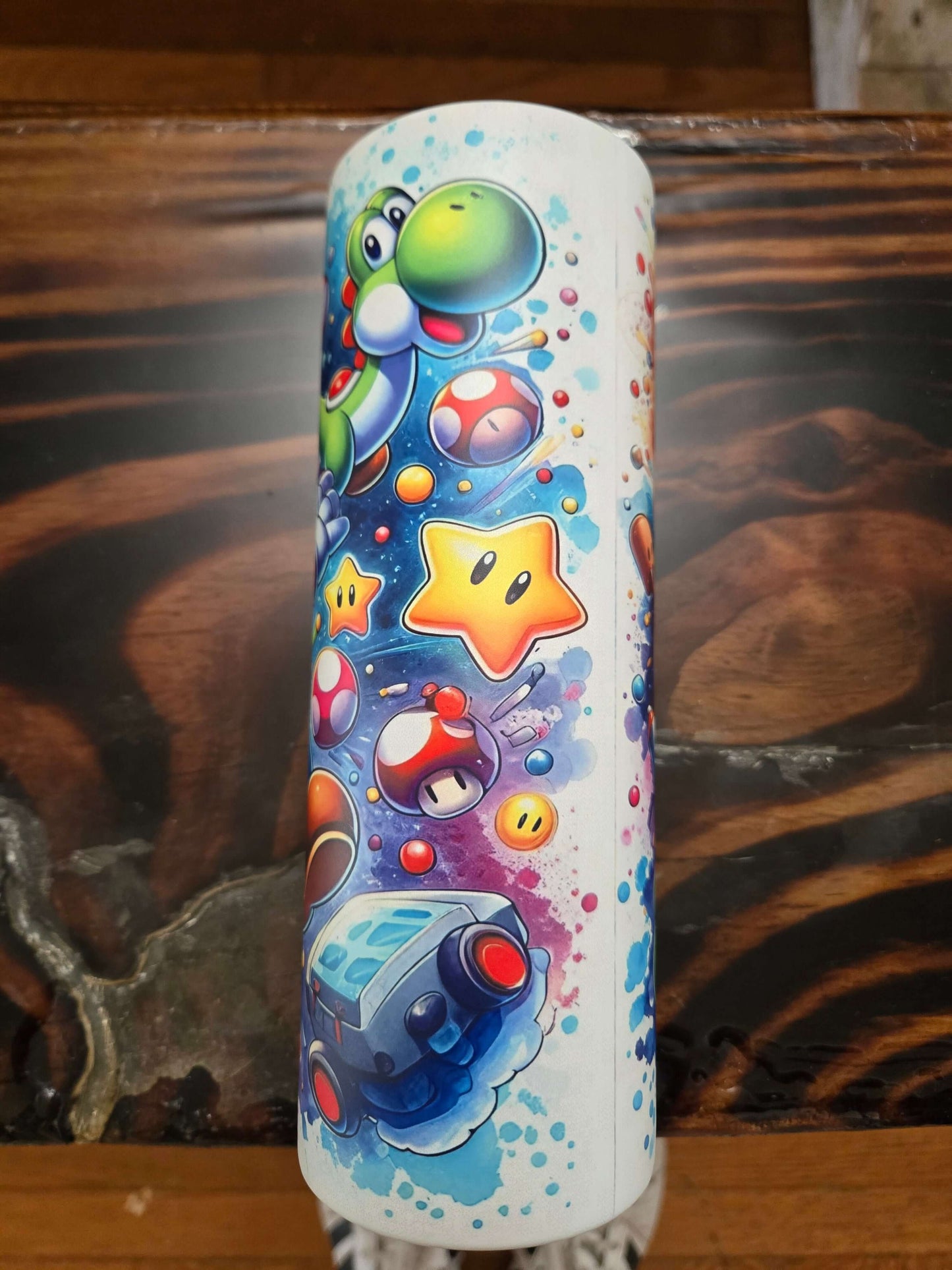 Colorful Mario Brothers tumbler featuring Yoshi, stars, and iconic items from the beloved cartoon series.