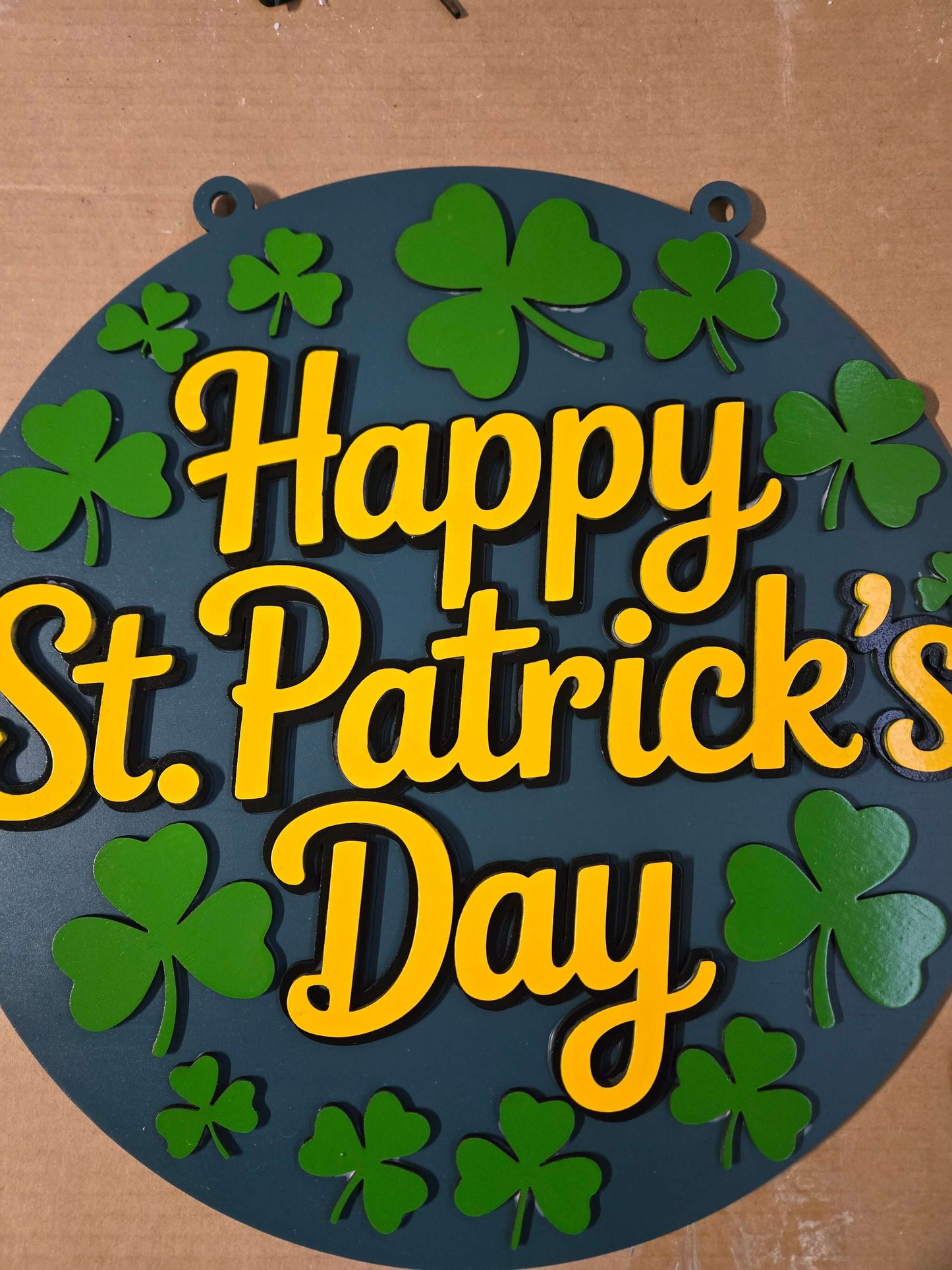 Happy St. Patrick's Day wooden sign with green clovers and vibrant yellow text.