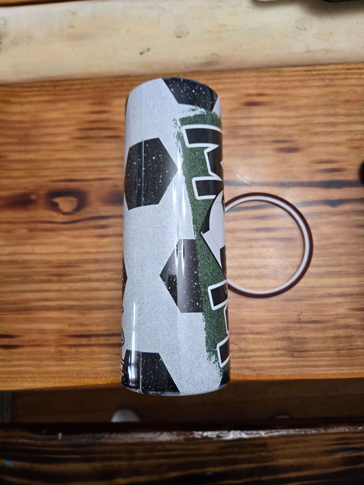 Soccer mom boss mom 20 oz tumbler cups featuring a stylish soccer ball design on a wooden surface.