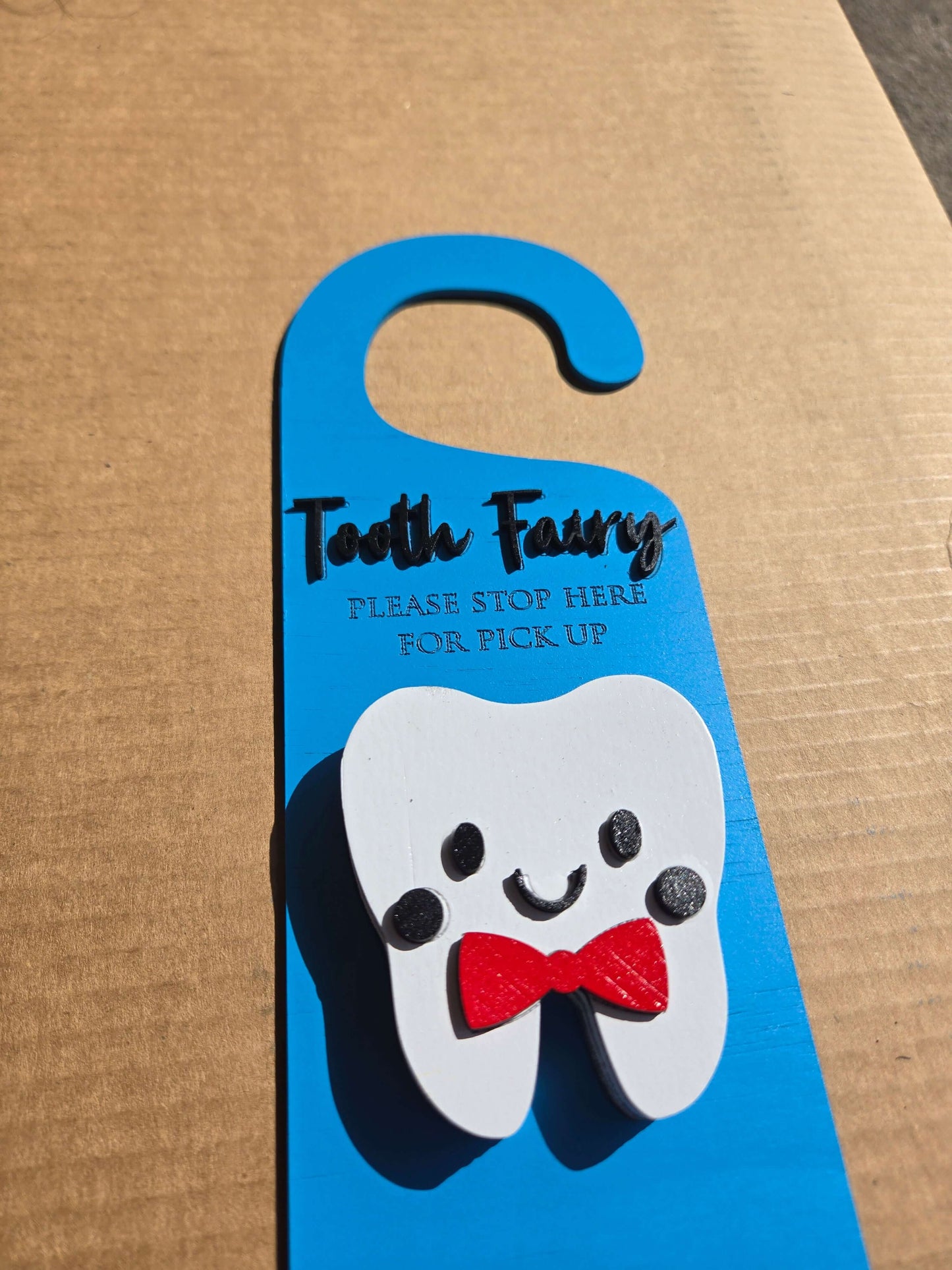 Tooth fairy door knob hanger with smiling tooth design, perfect for kids' bedtime traditions.