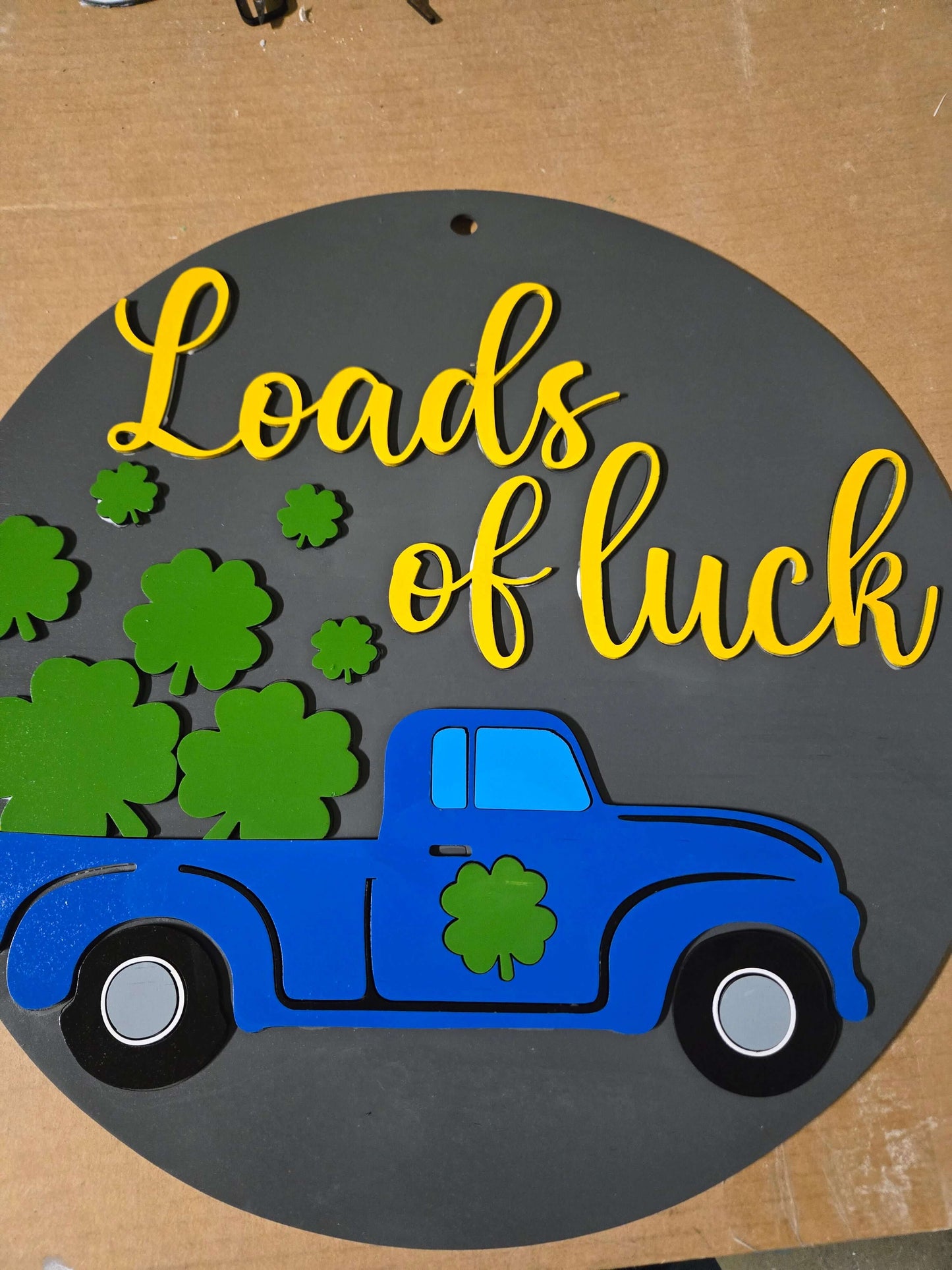 St. Patrick's Day Loads of Luck wooden sign with blue truck and green shamrocks for festive home decor.