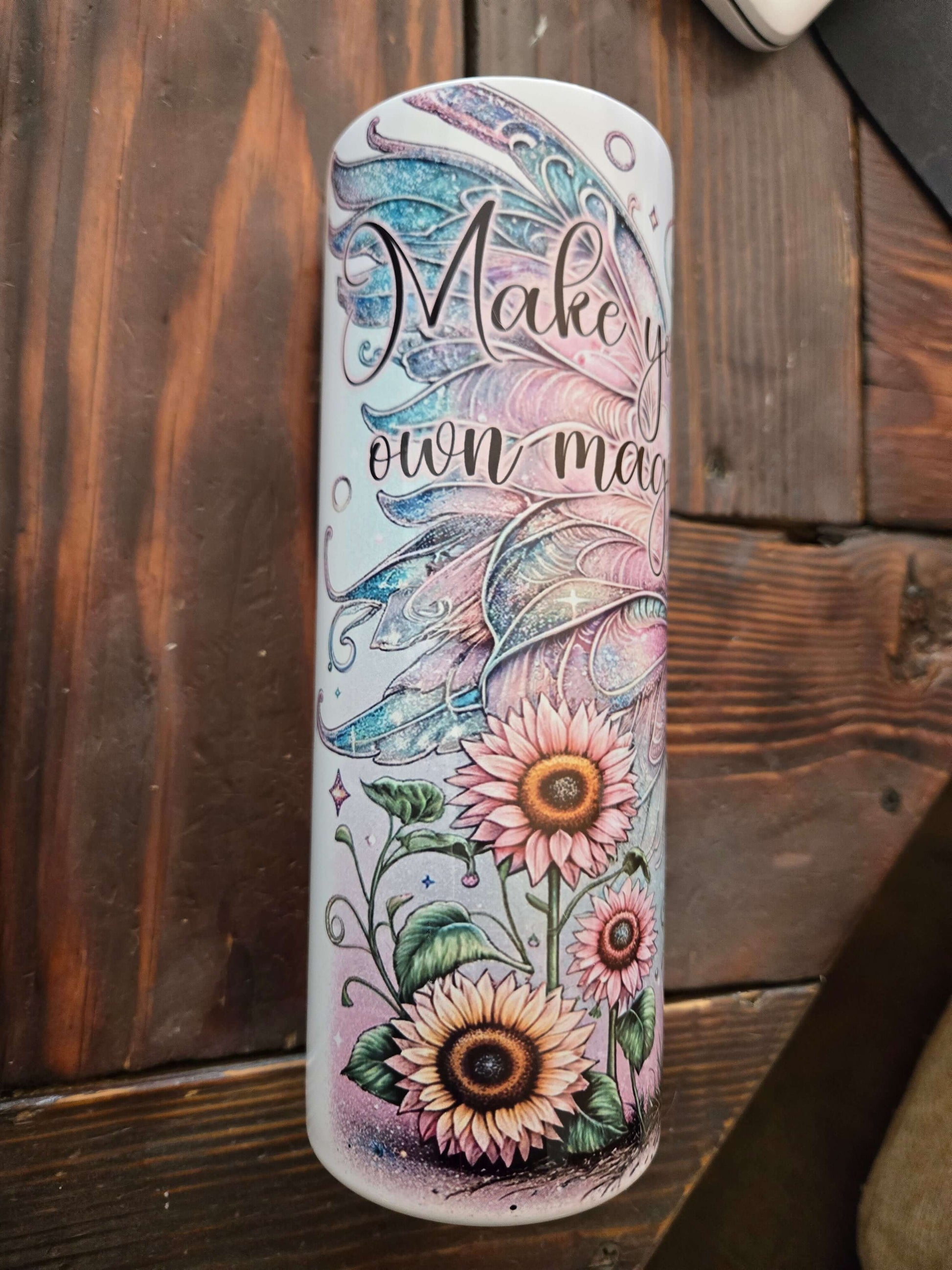 Colorful 20oz tumbler cup with floral design and 'Make Your Own Magic' text, ideal for travel and everyday use.