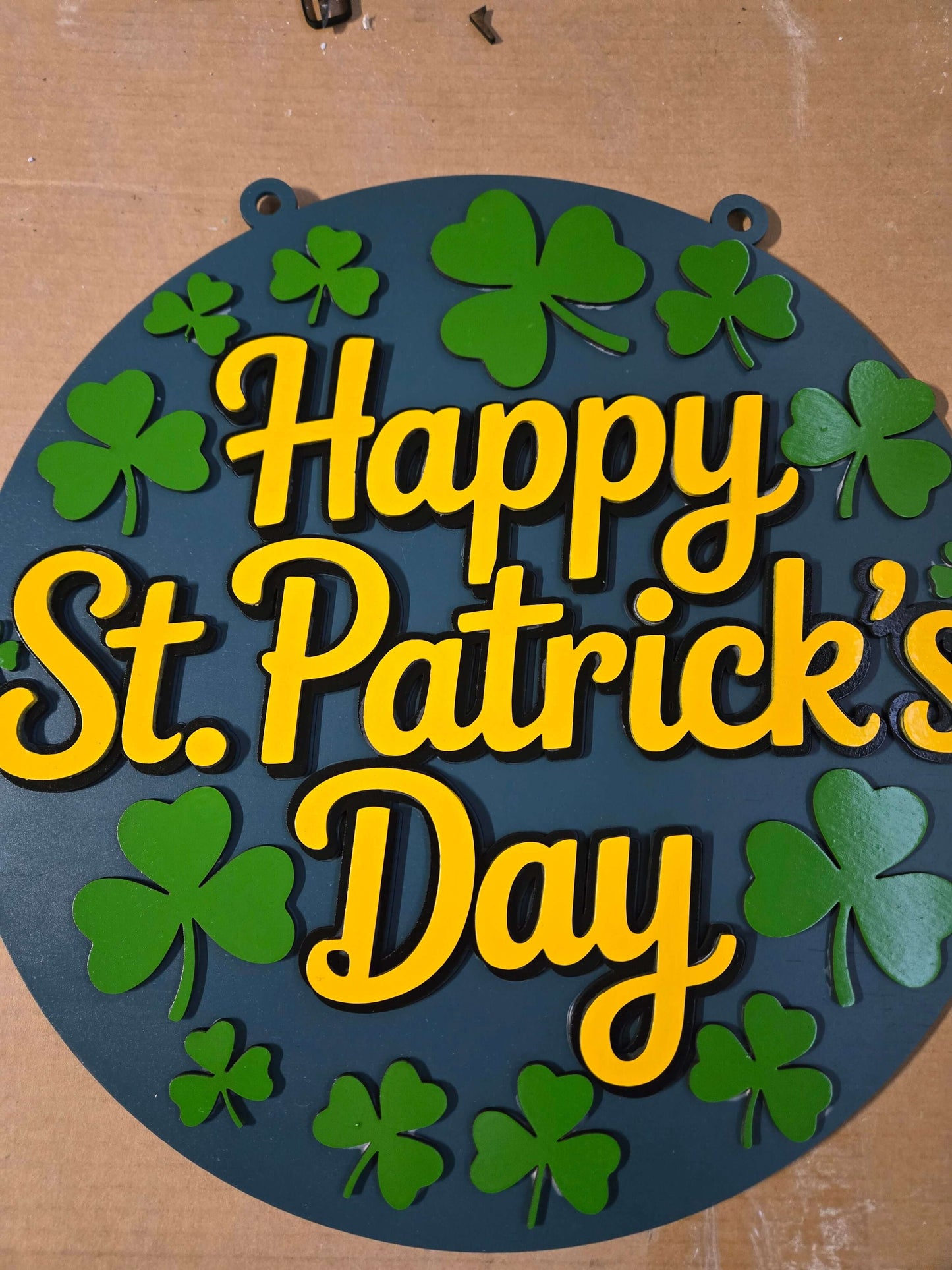 Happy St. Patrick's Day wooden sign featuring vibrant green shamrocks and cheerful lettering.