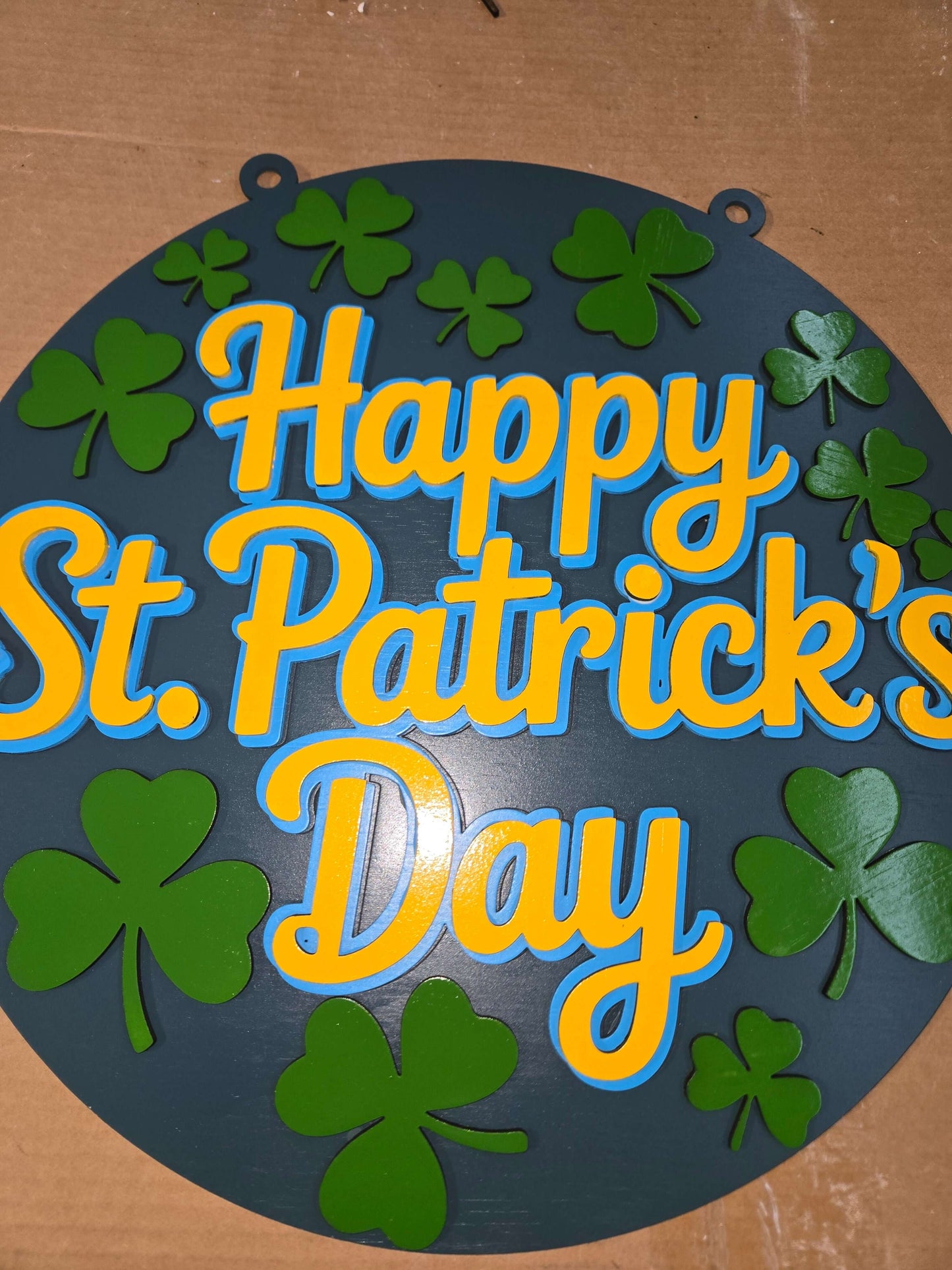 Happy St. Patrick's Day wooden decor sign with green clover designs and vibrant colors.