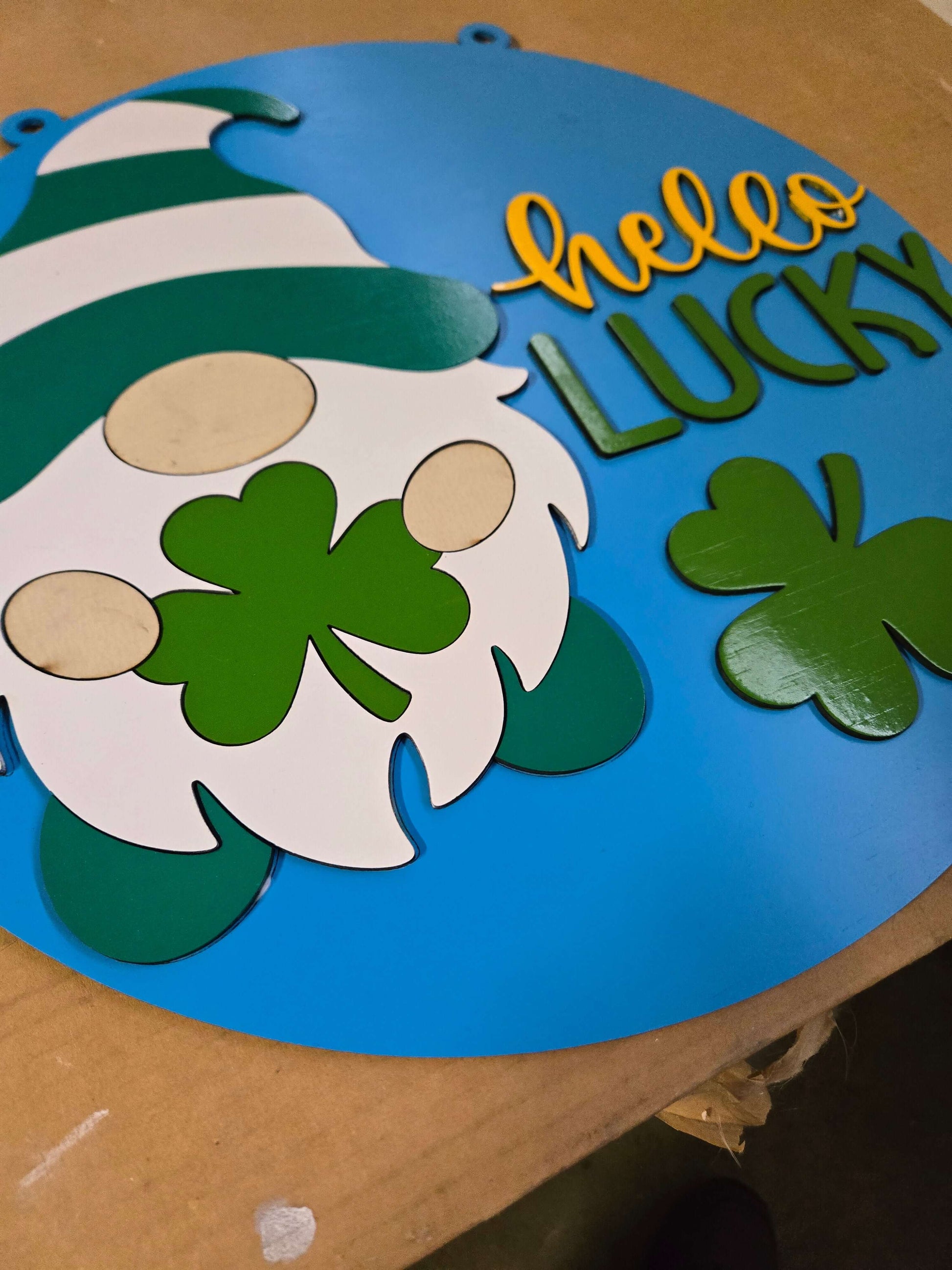 Hello lucky St. Patrick's Day gnome sign with green clovers on a blue background.